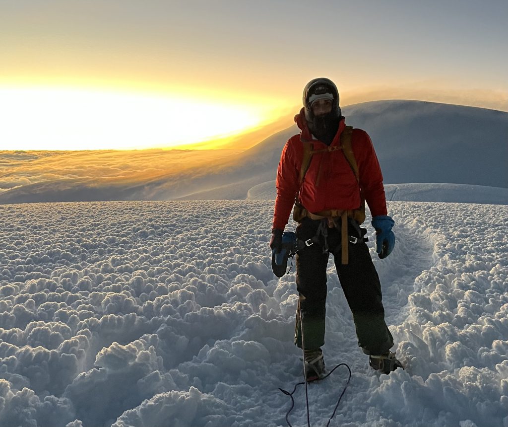 Noam at the summit of Chimborazo with the sunrise in the background