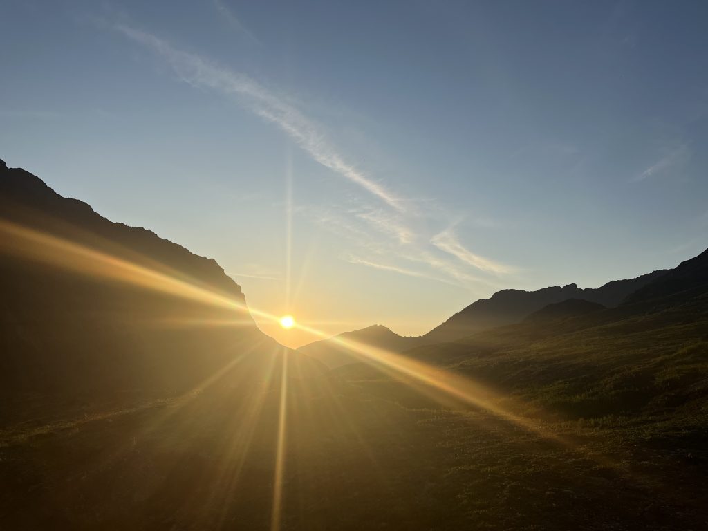 Sun setting between two mountains in the Alaskan wilderness