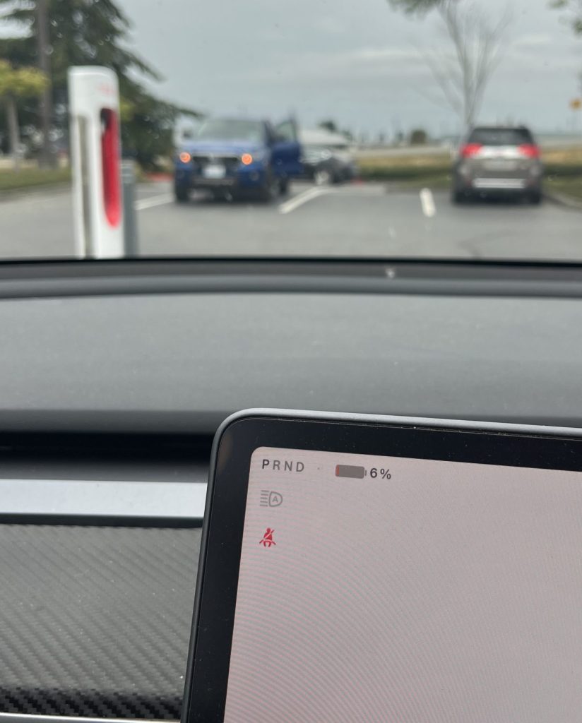 Tesla dashboard showing 6% battery remaining while parked at a Supercharger station.