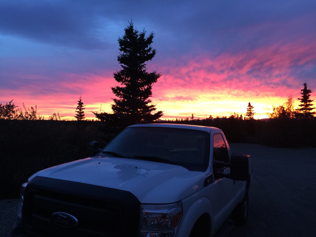 A truck with a sunset in the background in Alaska