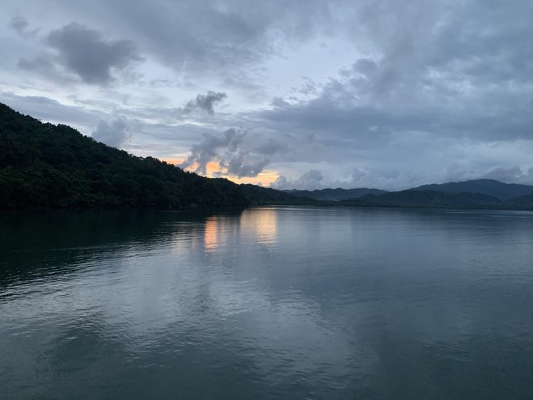 Sunset over calm waters near Paquera, Costa Rica, with reflections of the sky on the ocean